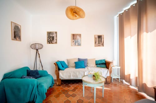Séjour lumineux au Mas De La Clé D'Or avec sièges turquoise, sols en terre cuite et lumière naturelle à Puget sur Argens