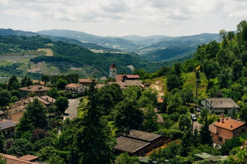 Lodole Country House immersa nelle dolci colline di Monzuno con campanile, circondata da verde rigoglioso in stile toscano