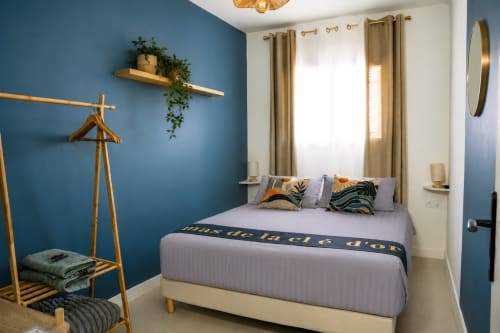 Chambre moderne du Mas De La Clé D'Or aux murs bleus, accents bois et décoration élégante à Puget sur Argens