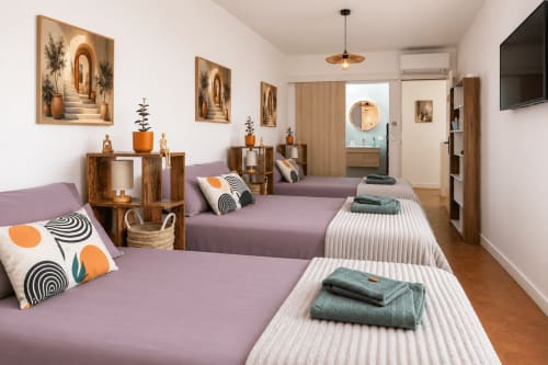 Chambre dorm moderne au Mas De La Clé D'Or avec lits violets, décor bois et lumière naturelle à Puget sur Argens