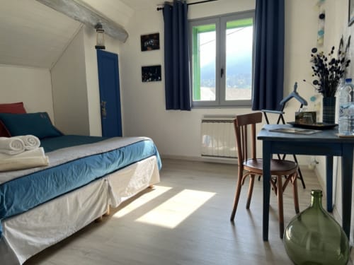 Chambre moderne et lumineuse à La Jument Verte en Provence, avec accents bleus, bureau et vue sur les montagnes