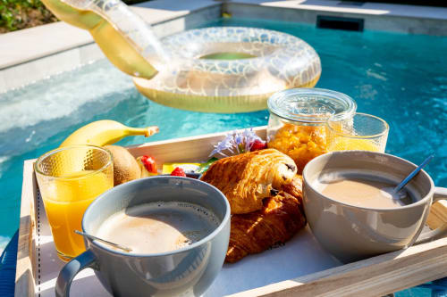 Petit-déjeuner luxueux au bord de la piscine du Mas De La Clé D'Or avec croissants, café, jus et cocktail à Puget sur Argens