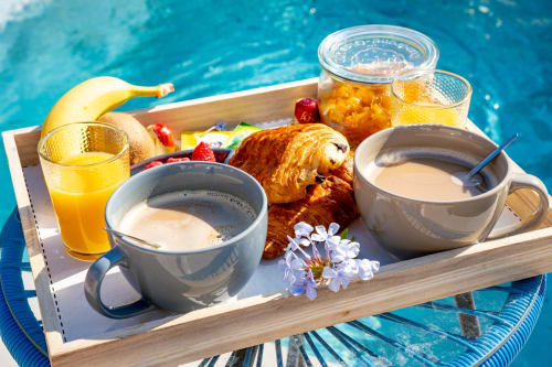 Plateau de petit-déjeuner luxueux flottant dans la piscine du Mas De La Clé D'Or, Puget sur Argens avec café, croissant, jus d'orange et