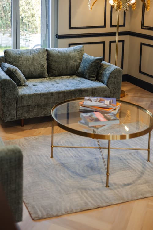 Élégant lounge à L'Ode à Pierre avec canapé gris, table basse dorée et décor contemporain à Dax