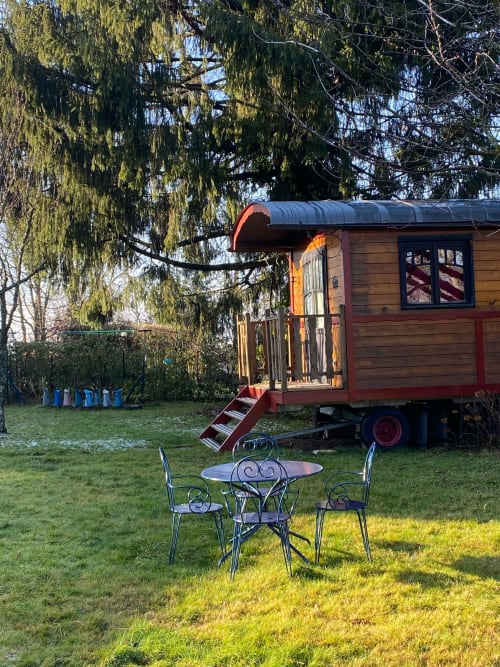 La Roulotte vintage caravan at La Jument Verte B&B in Southern France with seating area and willow trees
