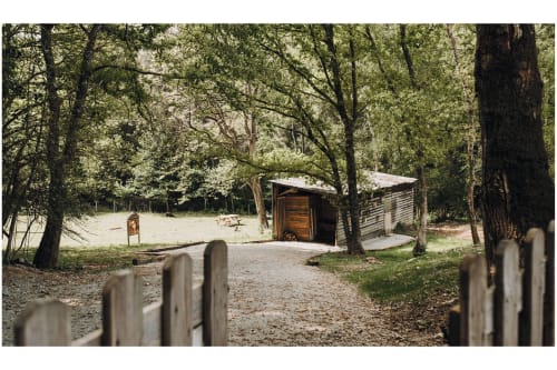 Rustic wooden cabin nestled among trees at Gites du Bulz, a charming bed and breakfast in Pleyber-Christ, France