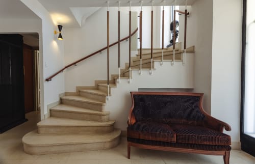 Escalier moderne aux marches en bois et rampe bordeaux à L'Ode à Pierre, Dax. Canapé vintage au premier plan.