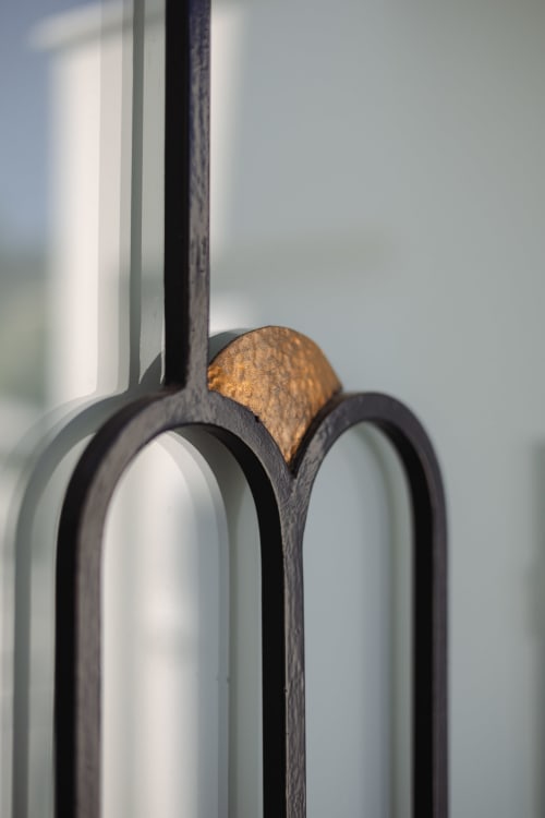 Détail de chaise en bois foncé avec accent en bronze à L'Ode à Pierre, Dax