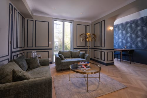 Le salon de luxe L'Ode à Pierre à Dax avec canapés gris, table ovale et panneaux muraux géométriques