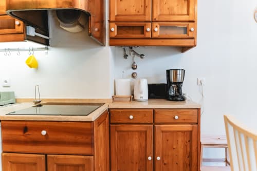 Wooden kitchen with coffee machine, kettle, and appliances in Cascais Garden House apartment