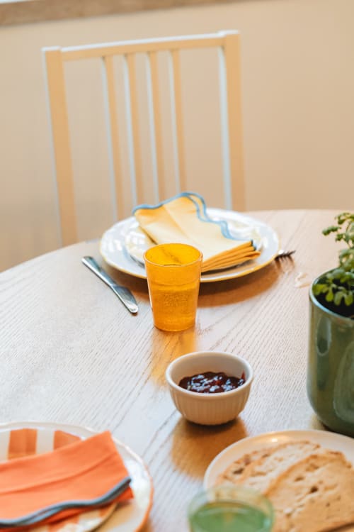 Dining table at Arestas e Planetas Cascais with orange juice, crackers, jam, and place settings