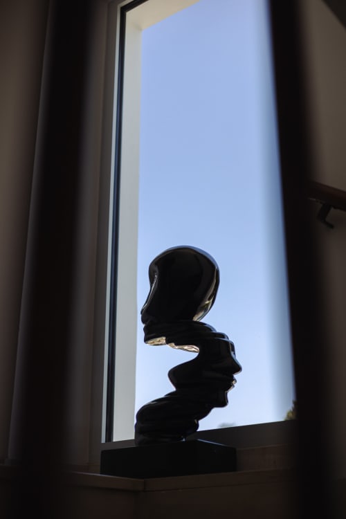 Buste sculptural noir en silhouette devant une baie vitrée lumineuse à l'hôtel-boutique L'Ode à Pierre à Dax, France