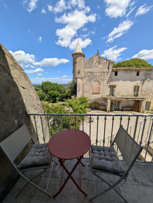 Balcony seating overlooking medieval castle tower at Domaine de Pelican in Gignac, France
