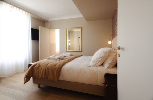 Chambre moderne à la L'Ode à Pierre B&B à Dax avec tons neutres, parquet et mobilier élégant