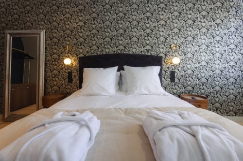 Chambre élégante à L'Ode à Pierre B&B à Dax avec papier peint à motifs, tête de lit noire et literie blanche