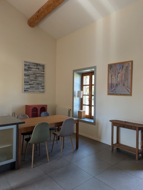 Bright dining room in Domaine de Pelican villa with wooden table, modern chairs, and garden views through French doors