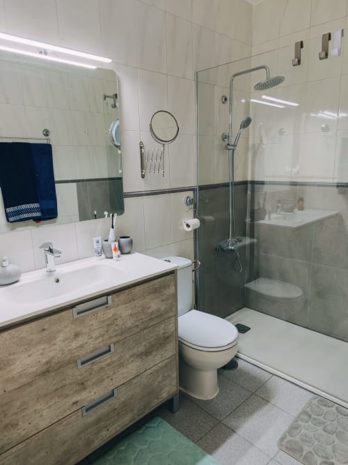 Baño moderno en apartamento Casa Ormì, Corralejo con ducha abierta, mueble de madera y azulejos blancos