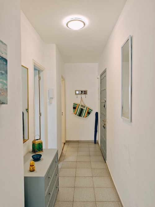 Pasillo luminoso del apartamento Casa Ormì en Corralejo con suelos de azulejos, espejos, almacenaje y decoración colorida