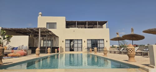 La villa beige de Riad Arkaya avec piscine, transats et parasols surplombant Essaouira, Maroc