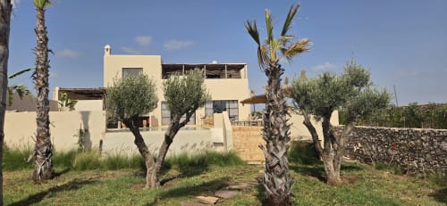 Hôtel Riad Arkaya à Essaouira, architecture crème avec palmiers et oliviers dans le jardin intérieur