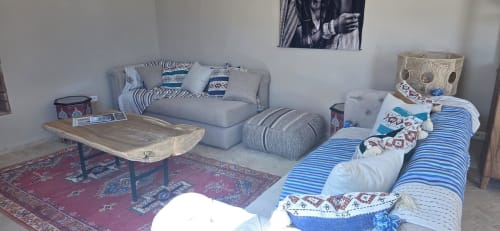 Chambre d'hôte du Riad Arkaya à Essaouira avec lit rayé bleu, zone de repos grise, table en bois et décor marocain traditionnel