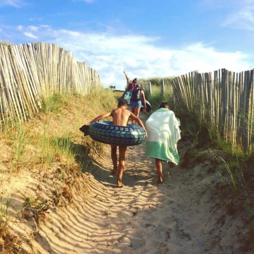 Children heading to beach through sand dune fence pathway at Gites du Bulz, Pleyber-Christ