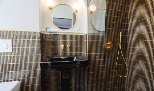 Salle de bains moderne du gîte L'Ode à Pierre à Dax avec lavabo noir, robinetterie laiton et carrelage géométrique