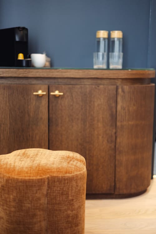 Coin cosy de la chambre L'Ode à Pierre avec meuble en bois, pouf et décoration murale bleue à Dax