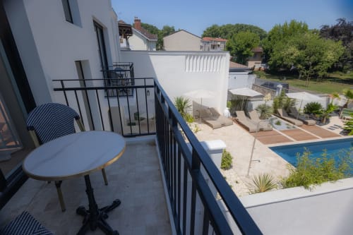 Vue depuis la terrasse de la chambre d'hôtes L'Ode à Pierre à Dax, avec piscine, transats et verdure environnante