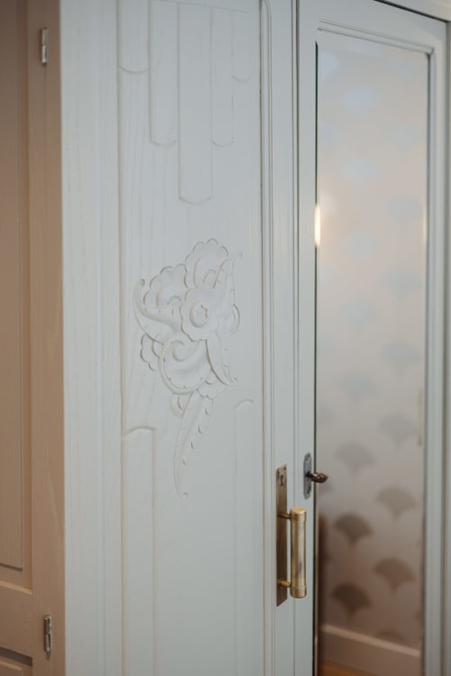 Portes de garde-robe blanches élégantes aux ornements floraux sculptés de l'hôtel boutique L'Ode à Pierre à Dax