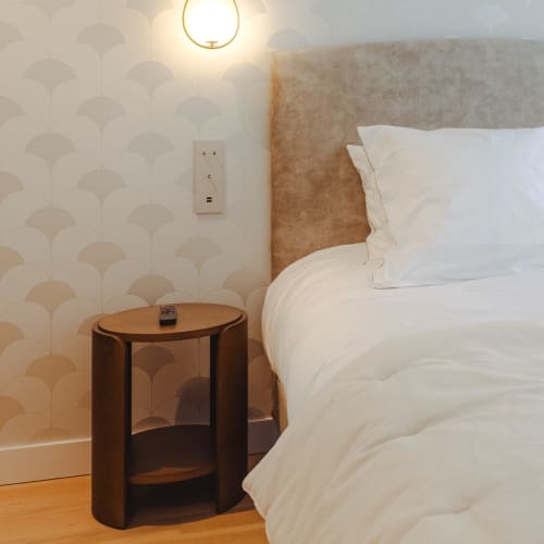 Chambre moderne à L'Ode à Pierre B&B à Dax avec literie blanche, tête de lit beige, table de nuit en bois et motifs géométriques
