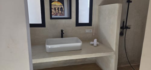 Lavabo moderne avec vasque blanche au Riad Arkaya à Essaouira, plan en pierre et miroir encadré