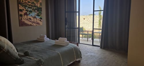 Chambre du Riad Arkaya à Essaouira avec vue sur le jardin, lit, serviettes et accès à la terrasse