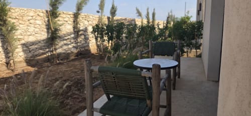 Terrasse de jardin du Riad Arkaya à Essaouira avec chaise verte, table ronde et vue sur la cour plantée