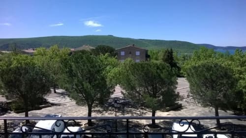 Vue depuis le balcon sur les oliviers, les collines verdoyantes et le lac au loin à l'Hôtel Le Verdon, Les Salles sur Verdon