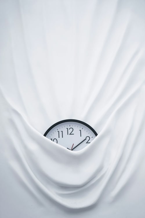 Clock mounted on white rippled wall at Ô Château hotel in Hayange
