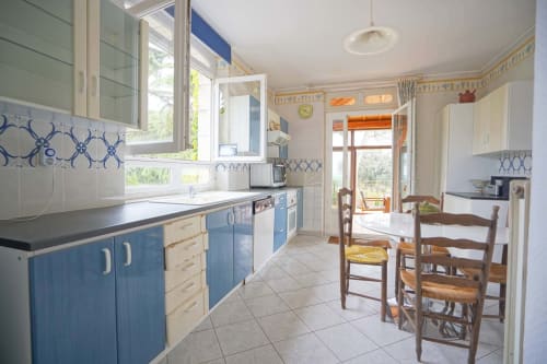 Cuisine lumineuse aux placards bleus et carrelages à motifs au Domaine les Olivoux, Pomport