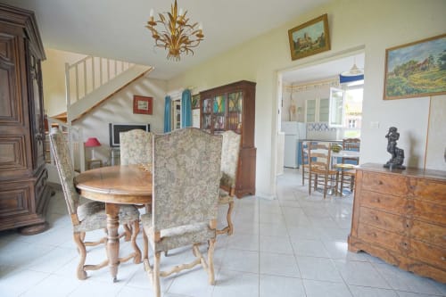 Élégante salle à manger du Domaine les Olivoux à Pomport avec table ronde, chaises à motifs et vue sur la campagne