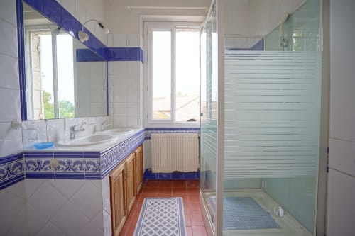 Salle de bain au Domaine les Olivoux avec vasque en carrelage bleu, douche et radiateur chauffant à Pomport.