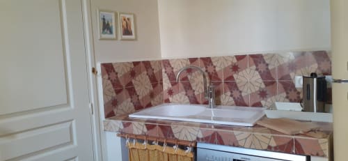 Cottage kitchen in Arles with decorative tile backsplash, white sink, and cooking amenities at Au coin de la Roquette