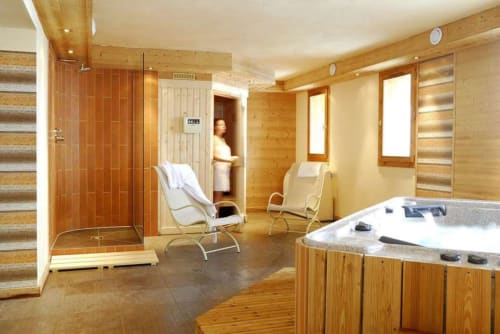 Espace spa luxueux du chalet Les étoiles de la Plagne avec bain à remous, douche, sauna et chaises de relaxation à La Plagne Tarentaise