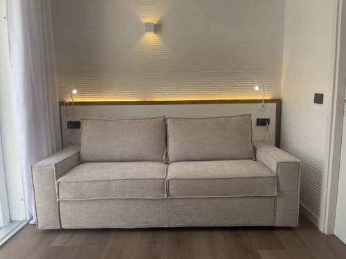 Divano beige moderno in camera loft di hotel con illuminazione d'accento e pareti texture a Like at Home Palau
