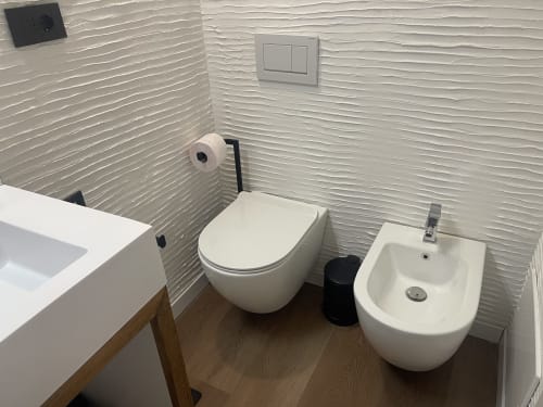 Bagno moderno a Like at Home Palau con WC bianco, bidet e lavabo su pareti texture