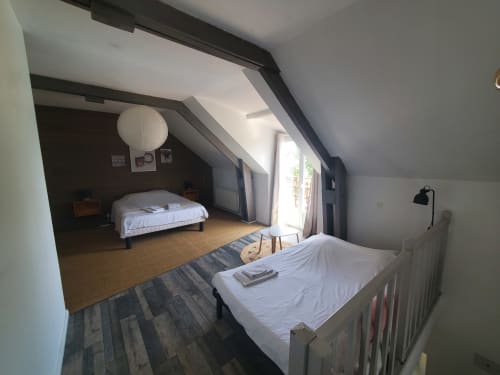 Spacious attic bedroom at Le Panoramique cottage in Isigny-sur-Mer with two beds, skylight, and garden views