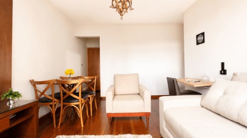 Sala de estar moderna no Wellington Rodovalho, Goiânia, com mesa de jantar em madeira, sofá creme e piso de madeira