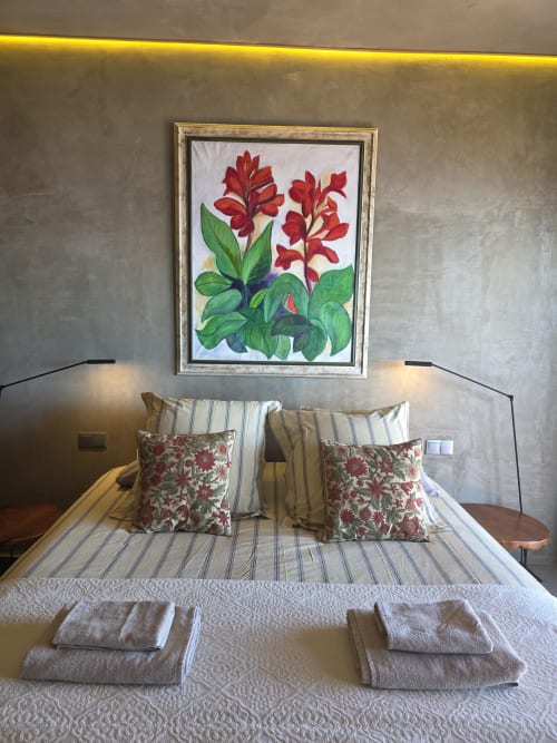 Quarto do hotel Les Terrasses Les Suites em Calheta com quadro de flor vermelha acima da cama listrada com almofadas decorativas