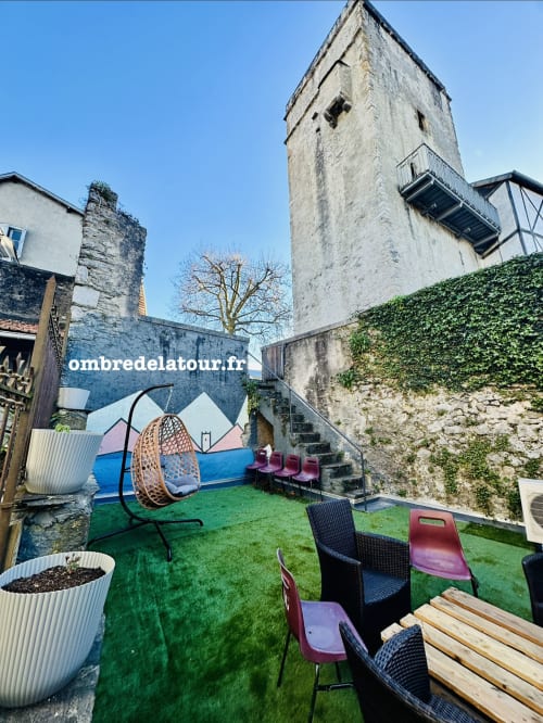 Cour de jardin de tour médiévale à l'hôtel Ombre de la Tour à Lourdes avec coin détente et gazon synthétique