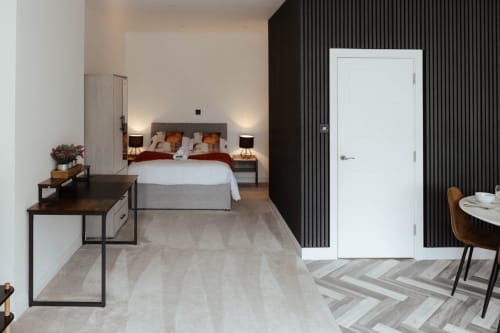 Modern bedroom at JS Apartments Collection Blackburn with bed, desk, and black accent wall