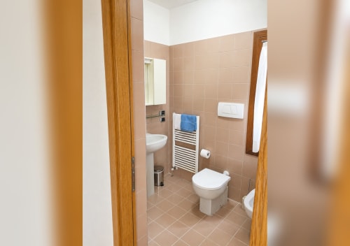 Moderno bagno della villa Il Nido a Treviso con doppi servizi igienici, scaldasalviette e piastrelle beige
