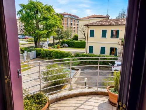 Vista dal balcone del cortile di Treviso con edifici storici, spazi verdi e parcheggio presso la villa Il Nido